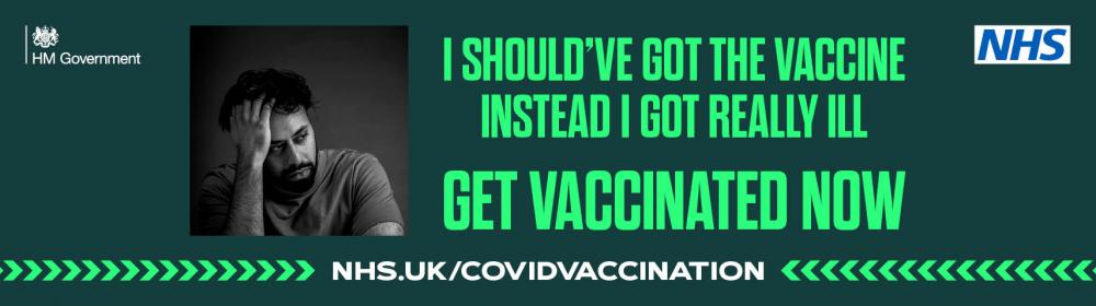 NHS banner, dark green background with lighter green text reading [I should've got the vaccine instead I got really ill. Get vaccinated now] with NHS logo top right, HM Govt logo top left and black and white image of male with head in one hand.