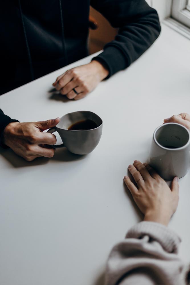 Two people sat at table with coffee cups