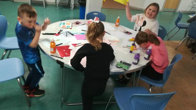 Four young carers at The Junction Foundation working on their Young Carers Action Day poster campaign