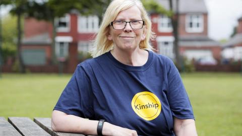 Local Kinship Carers, Angela, sat at a picnic table in Locke Park