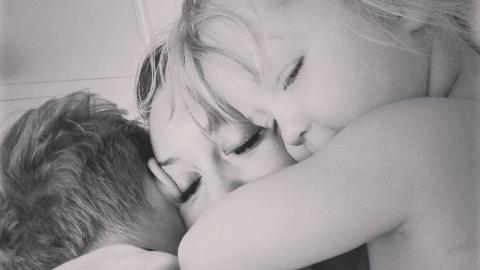 Black and white image of Abby hugging her son and daughter