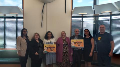 Kinship carers in parliament holding signs reading 'Kinship care bill' 